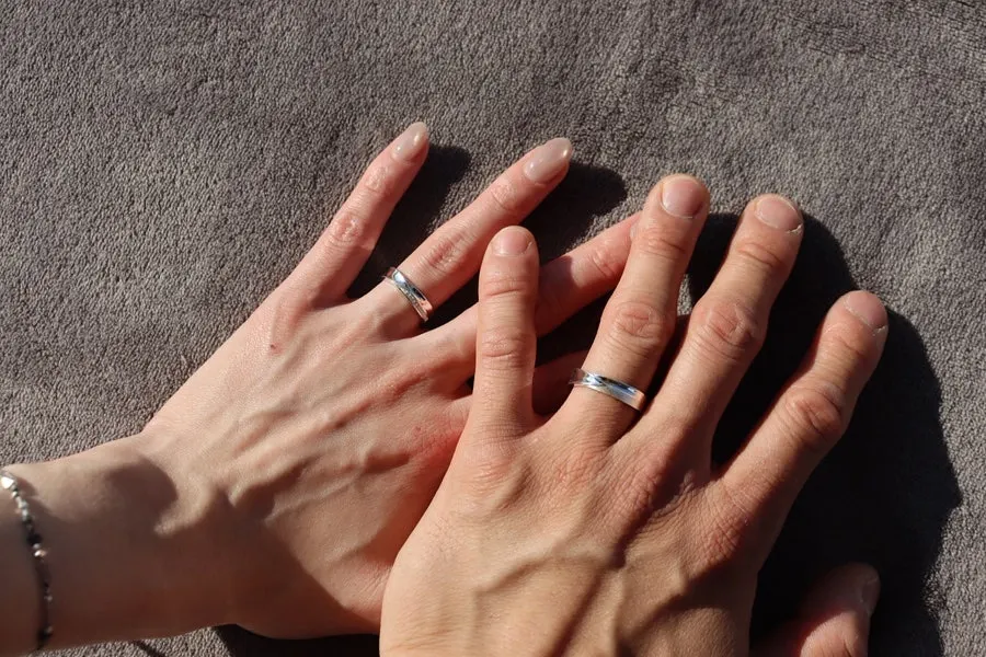 Two hands wearing the couple rings