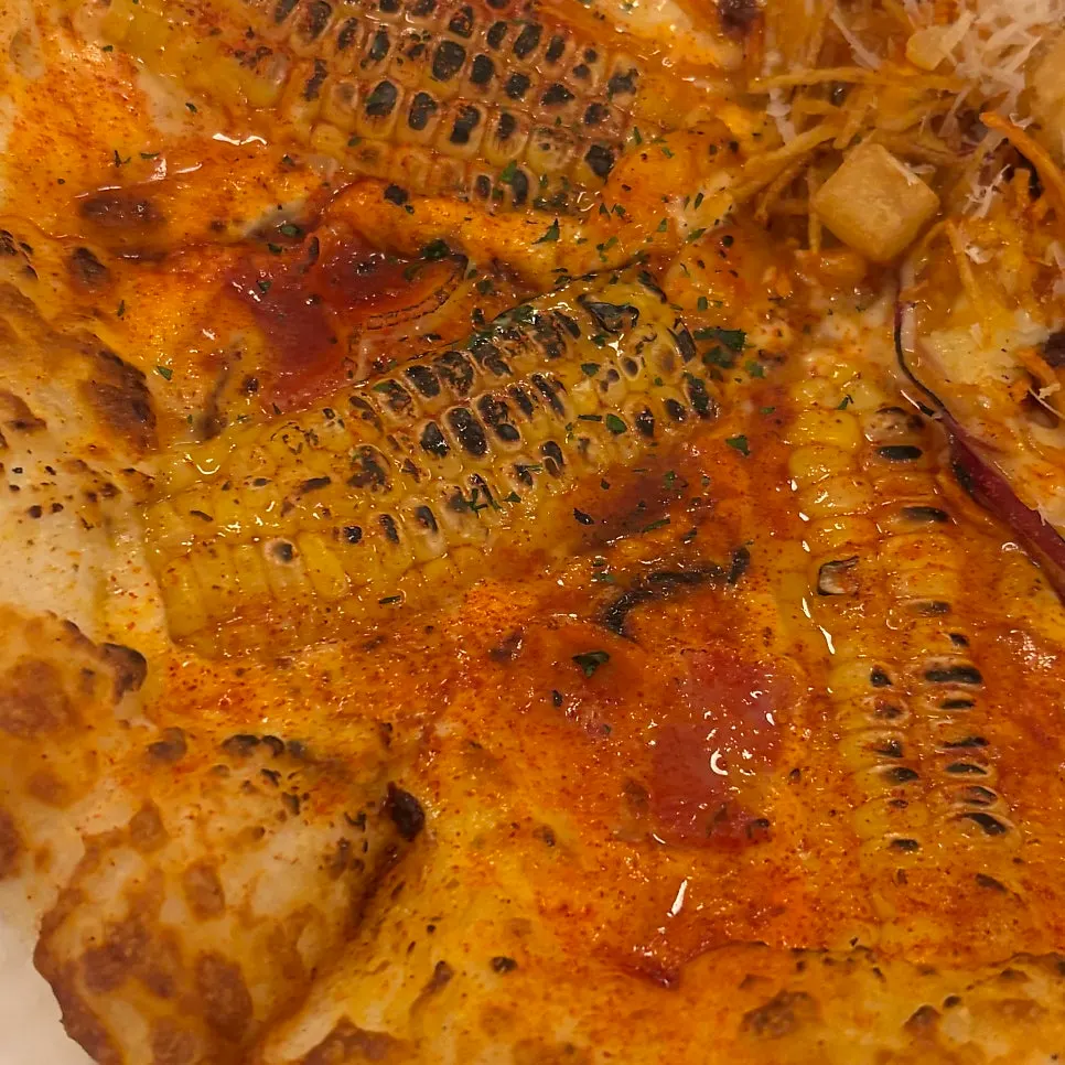 통옥수수가 올라간 옥수수피자 조각