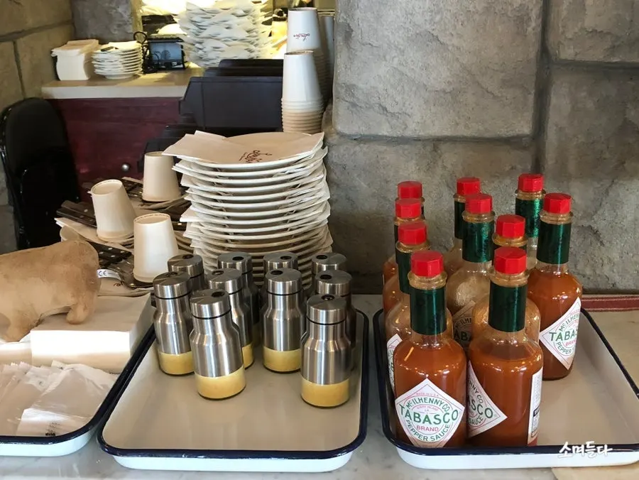 Self-service bar with Parmesan cheese and hot sauce