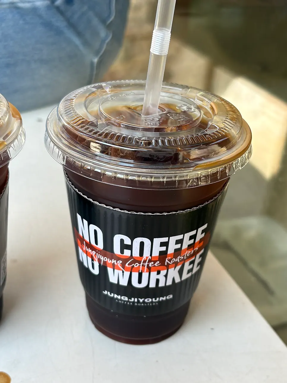 Two takeout Americanos with cup holders attached