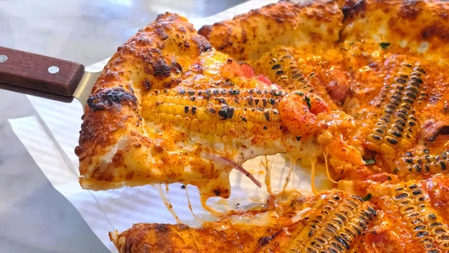Corn pizza shared with friends