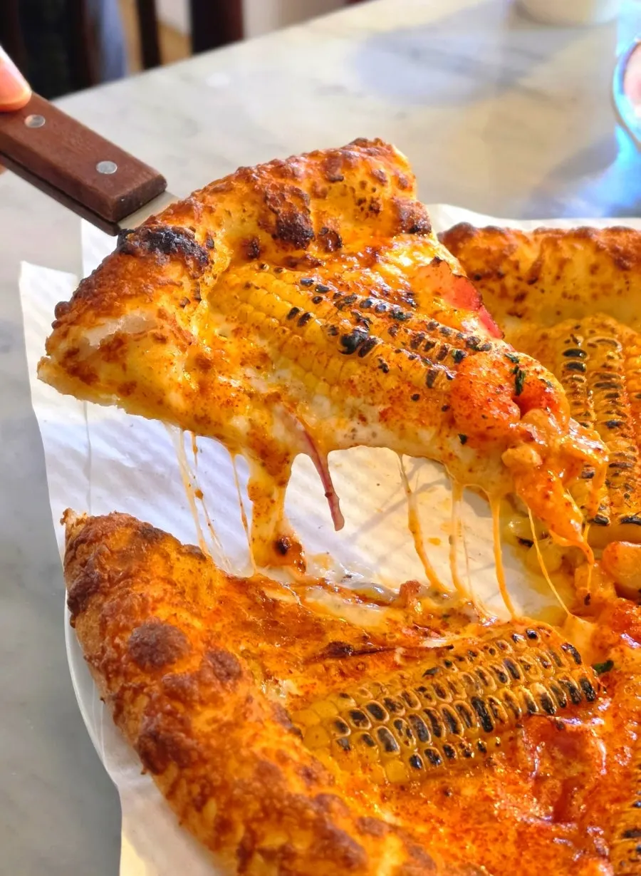 Cream sauce and toppings on corn pizza