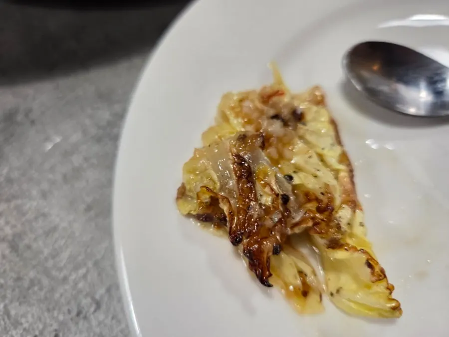 Grilled napa cabbage salad plated with dressing