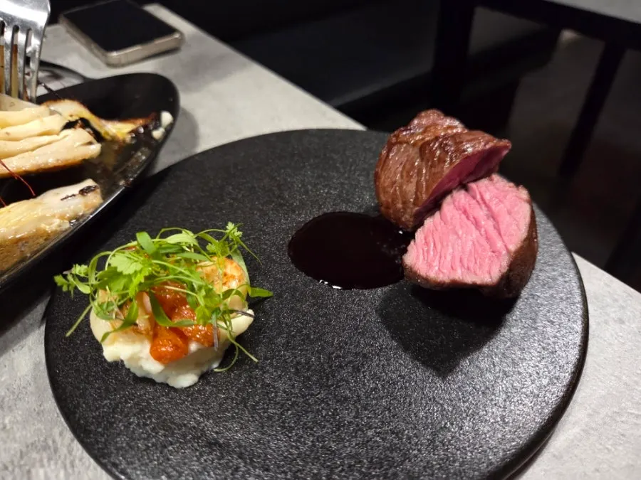 Steak served with carrots and other side vegetables