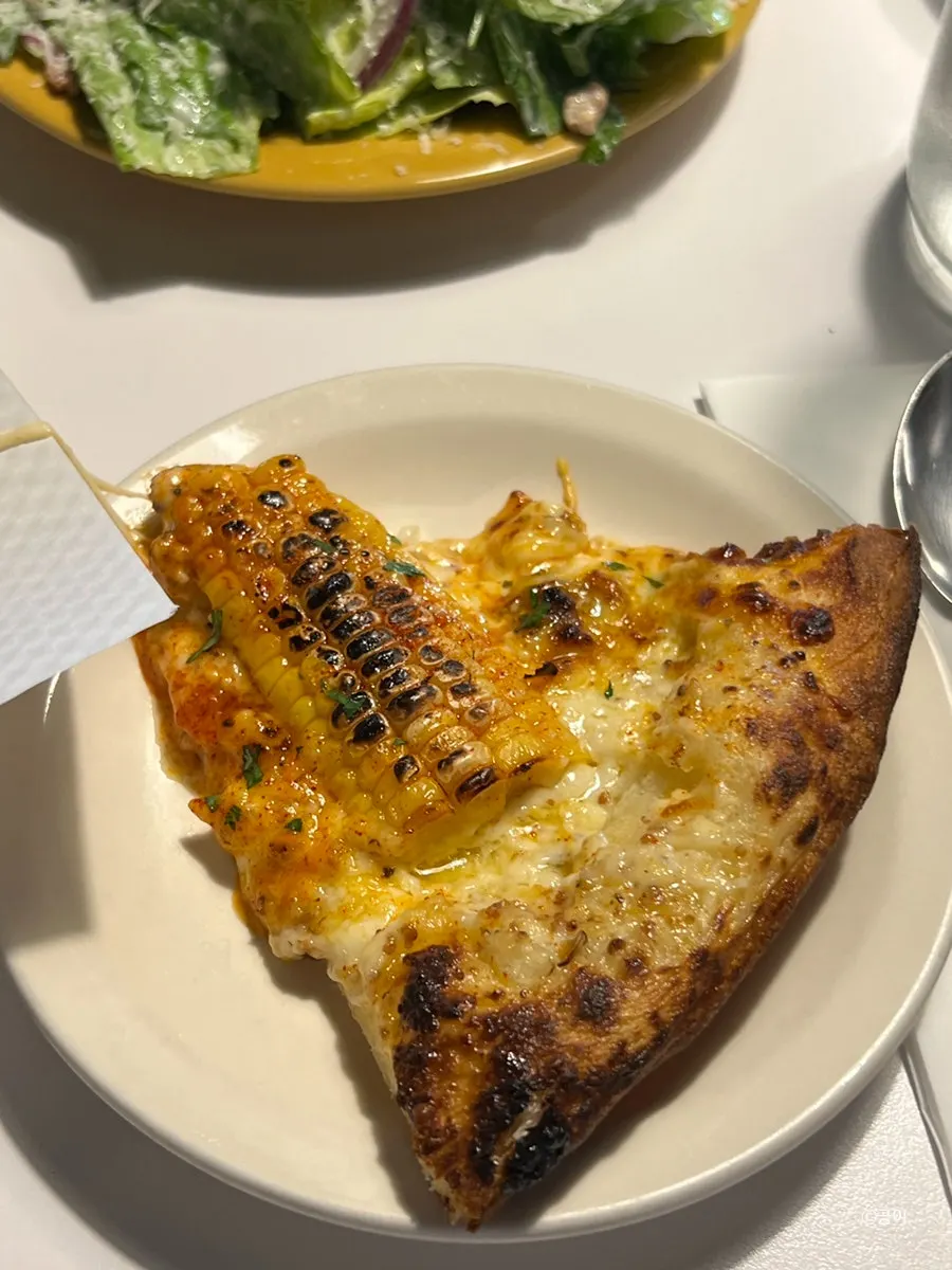 A slice of the corn-topped pizza