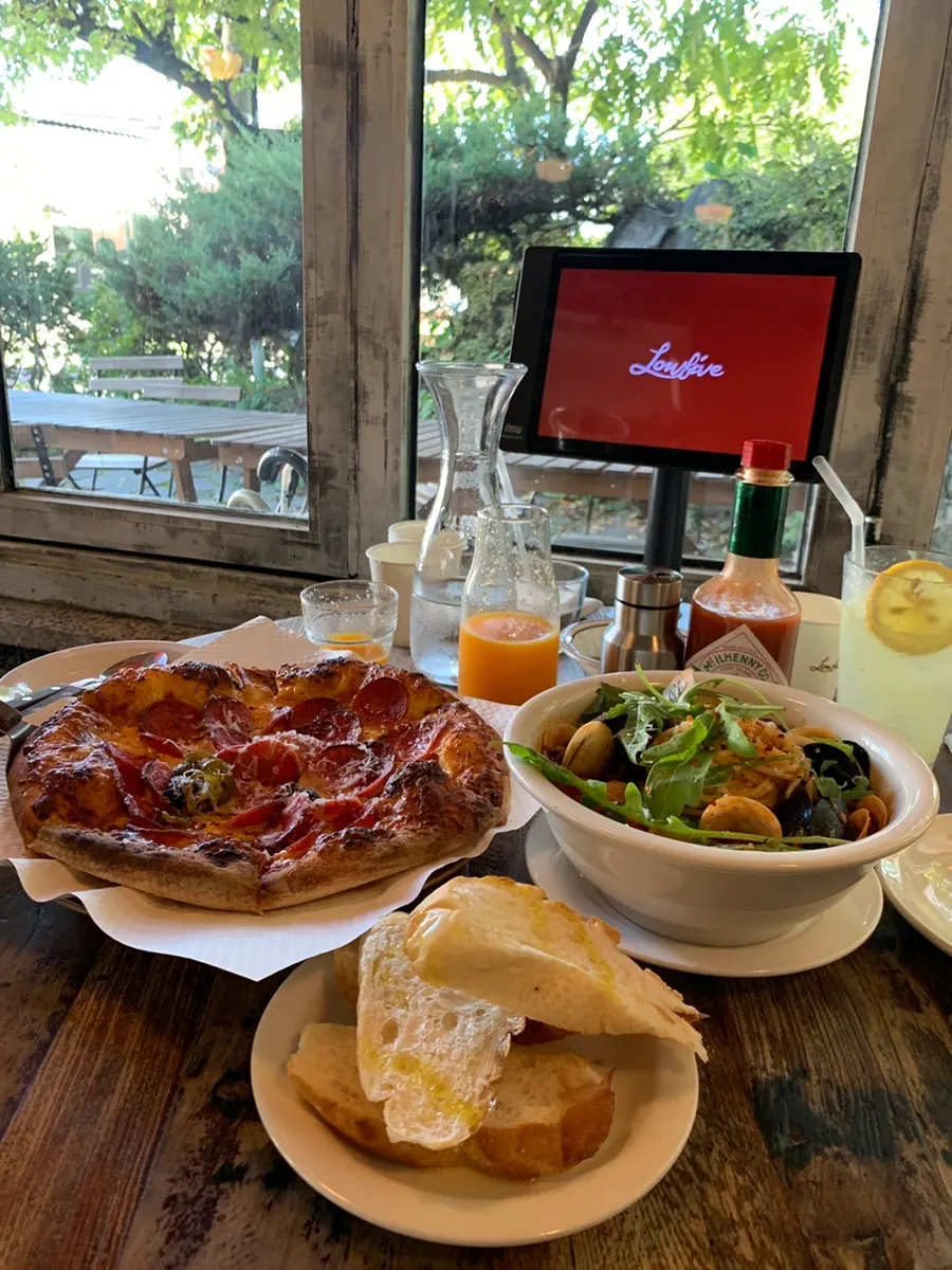 Full spread of pizza, pasta and drinks