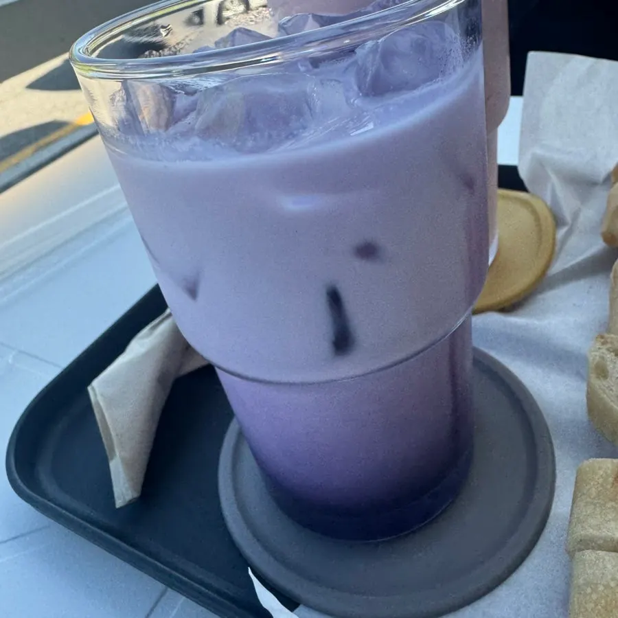 Strawberry yogurt smoothie held with the fortress wall in the background
