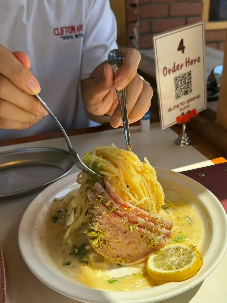 Close-up of pasta topped with charred lemon and mortadella