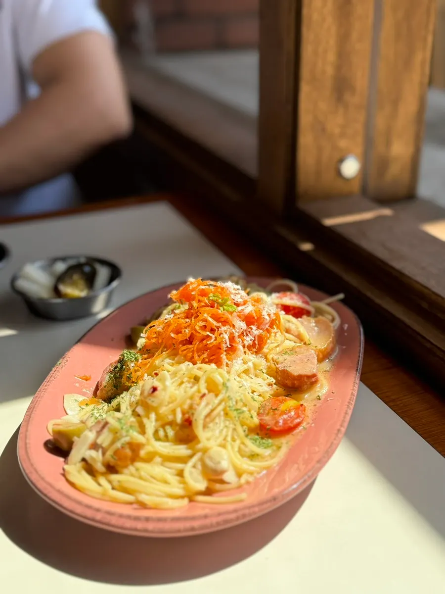 Aglio olio topped with julienned carrot and smoked duck
