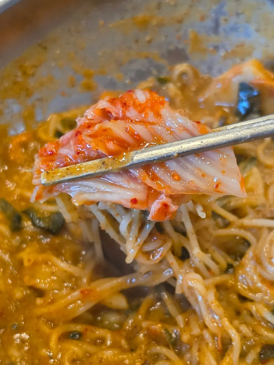 김치를 올려 먹는 어탕국수 한 젓가락