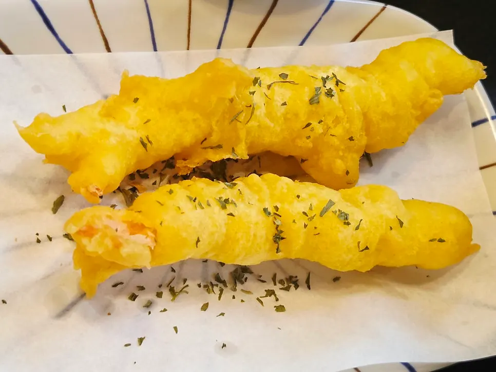 A piece of eel topped with seasoned chive salad