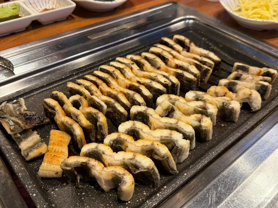 A table setting with a plump salt-grilled freshwater eel platter