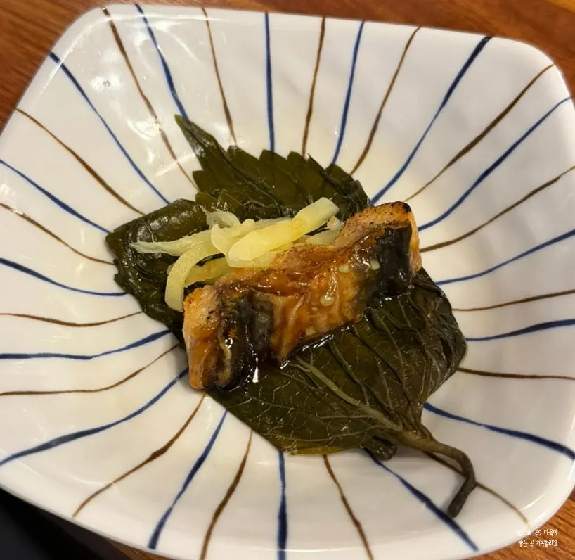 A piece of grilled eel dipped in sauce