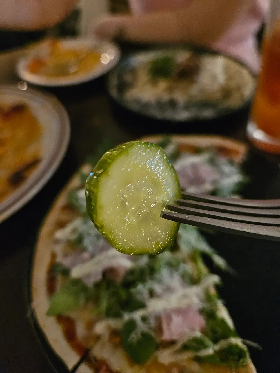 Pickles served alongside the thin pizza