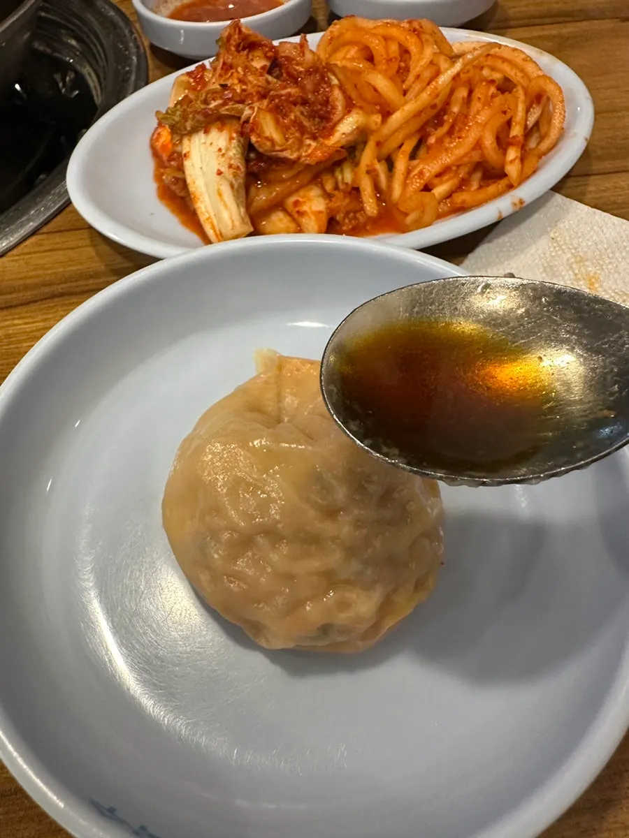 만두 하나를 집어 든 모습