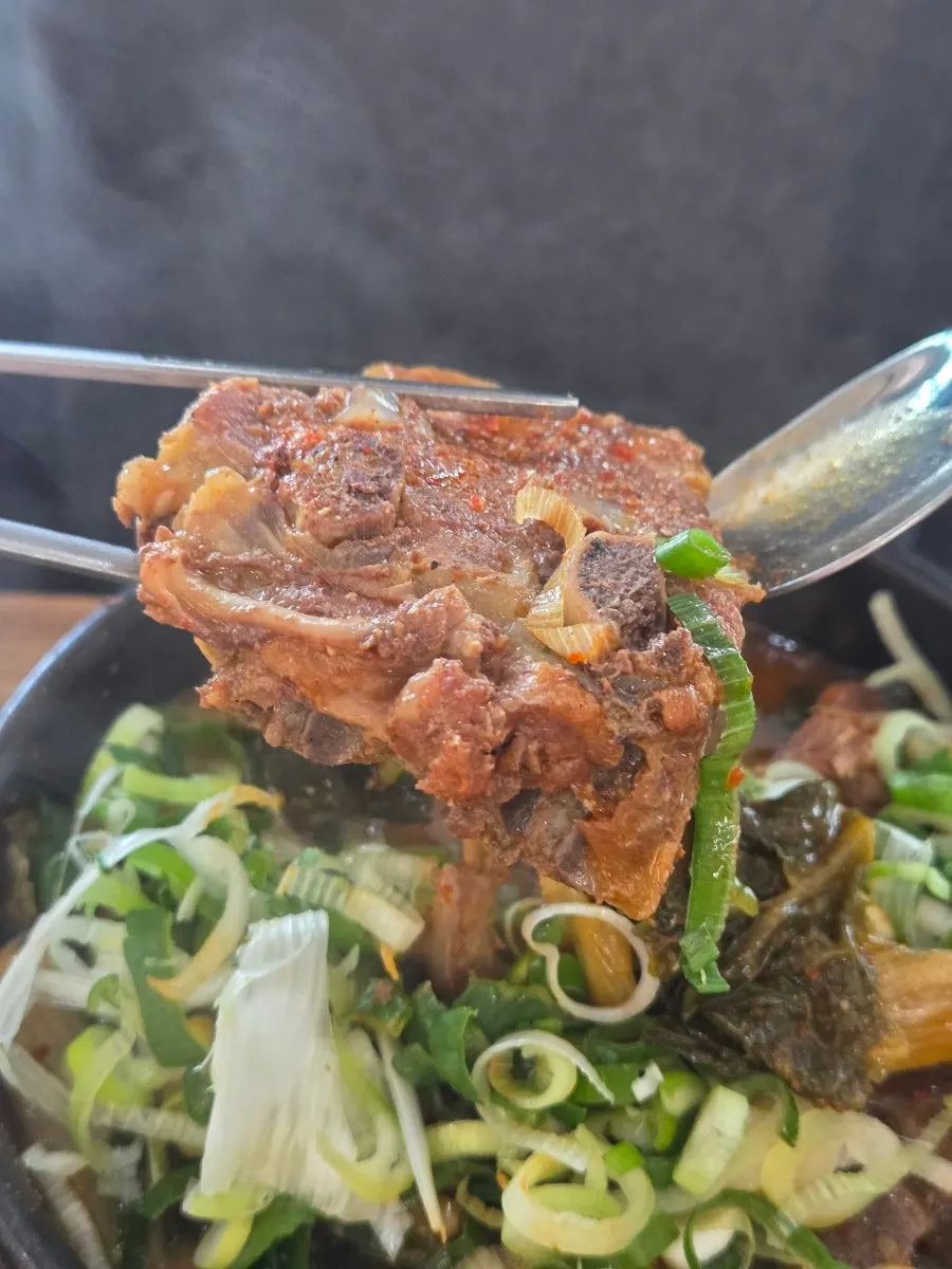 Couple sharing bites of their haejangguk dinner