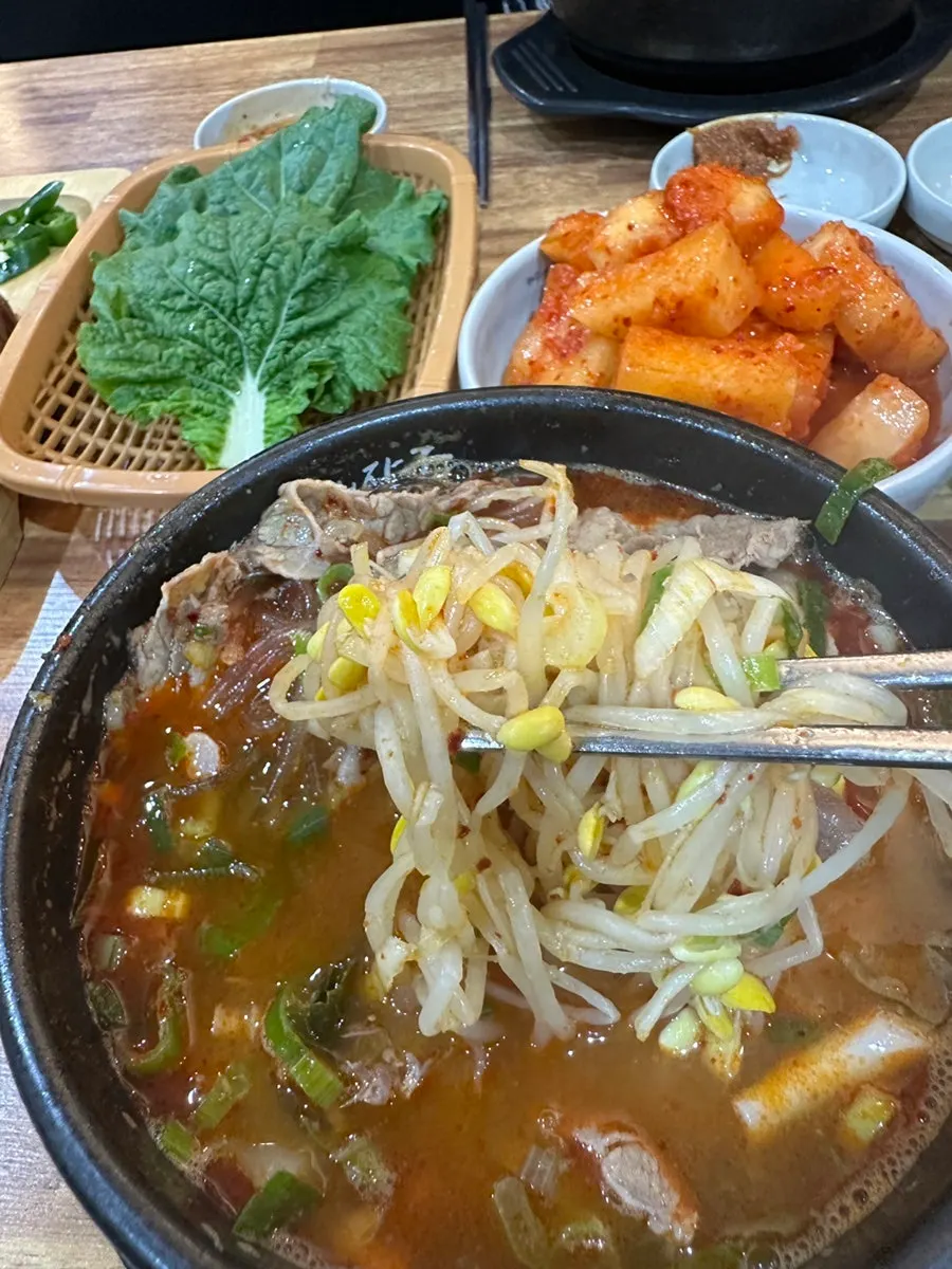 Hangover soup broth topped with green onion and bean sprouts
