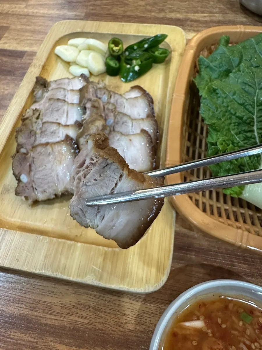 A piece of dombe pork picked up with chopsticks