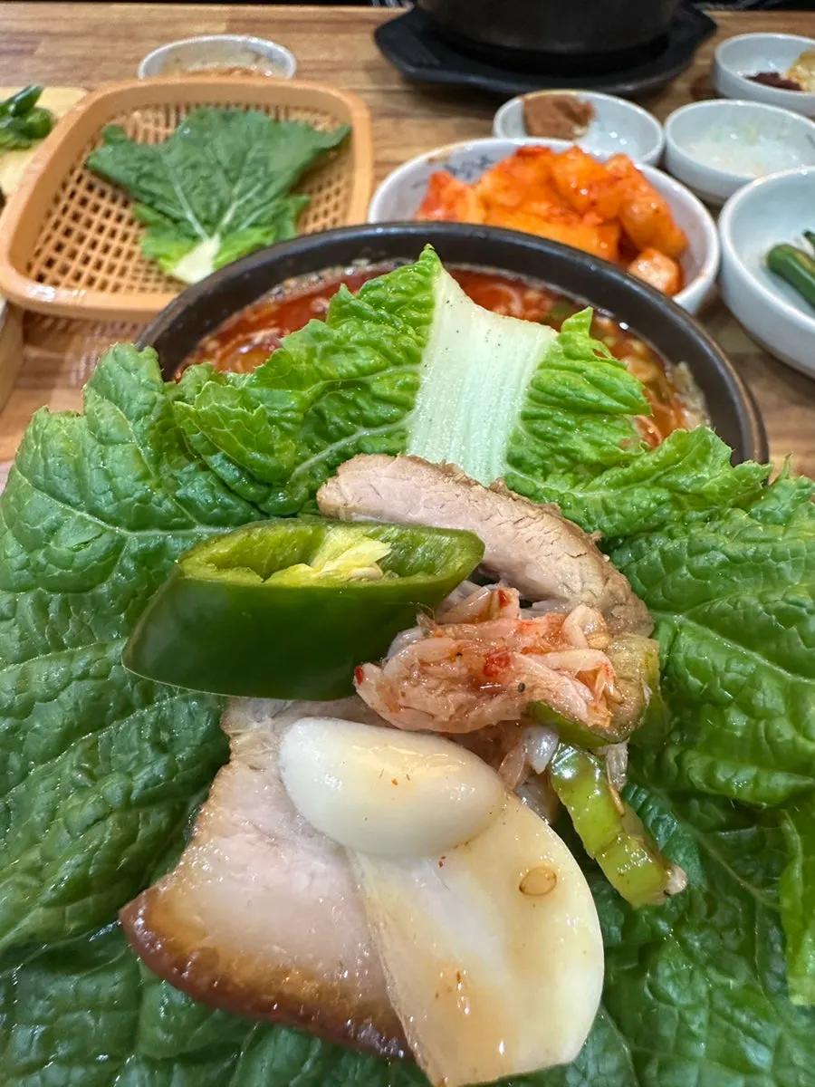 Dombe pork and kimchi piled on a lettuce leaf