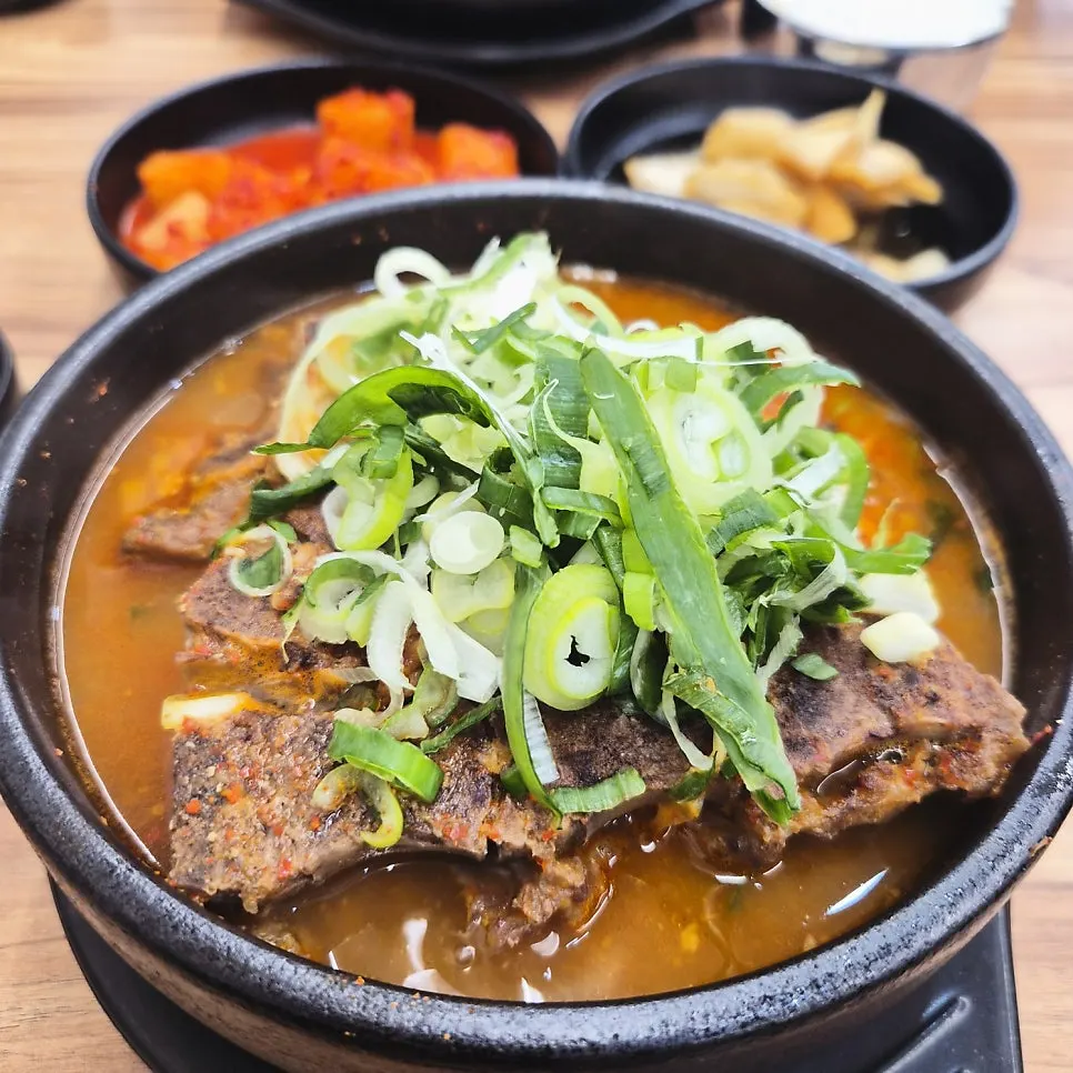 Bright red seasoned kkakdugi and pickled onion side dishes