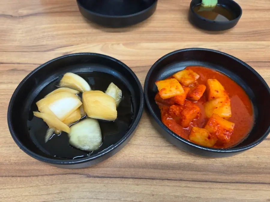 Pickled onions and diced radish kimchi served as sides