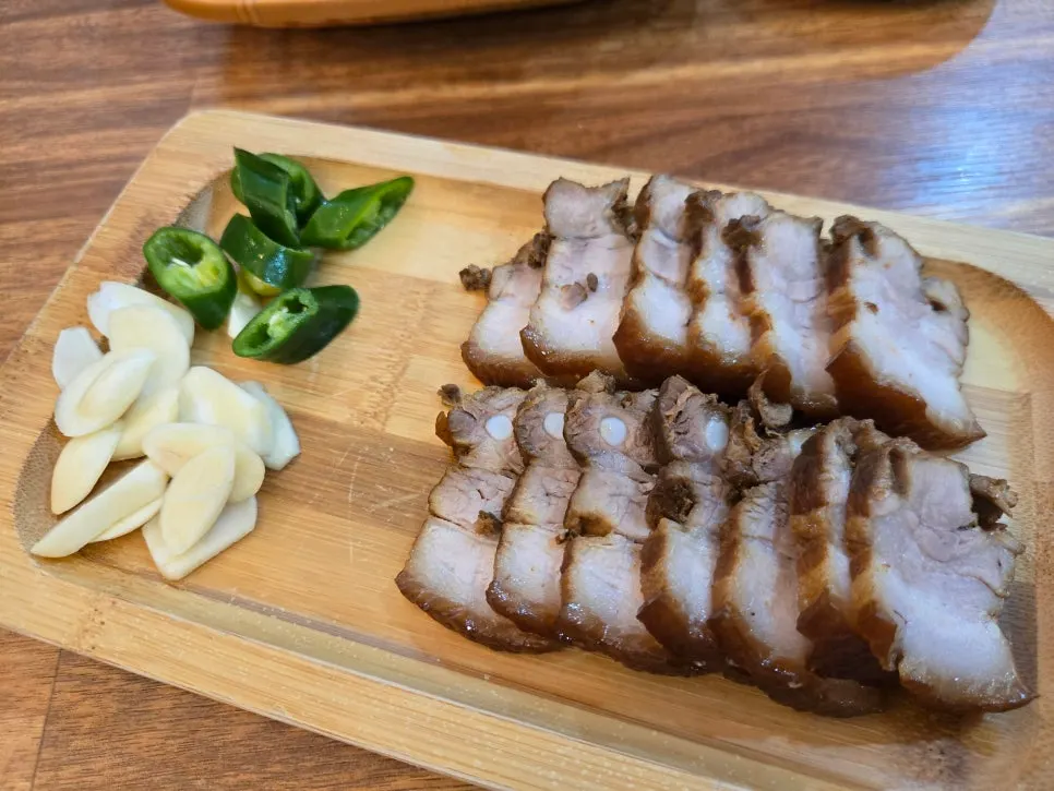 Dombe pork served with garlic, peppers, salted shrimp, and lettuce wraps