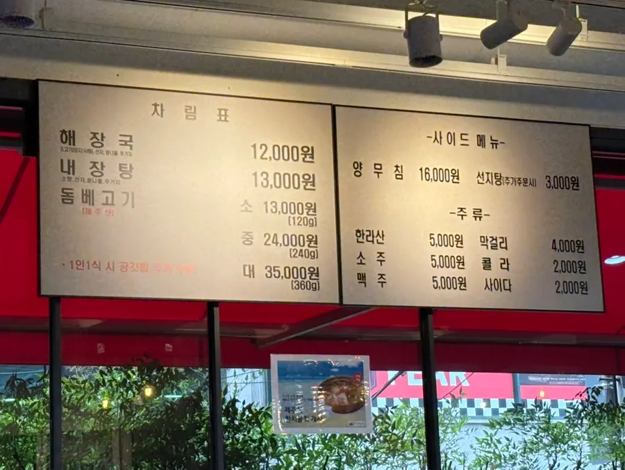 Menu board listing haejangguk, tripe soup, and dombe pork prices