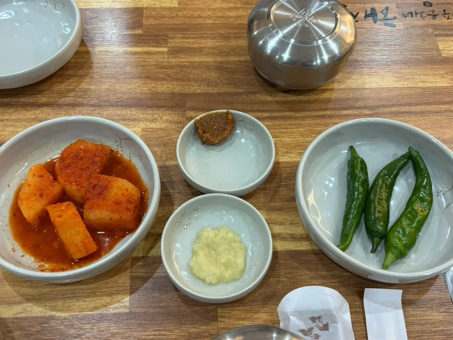 Side dish plate with seokbakji, cheongyang chili, and dipping sauce
