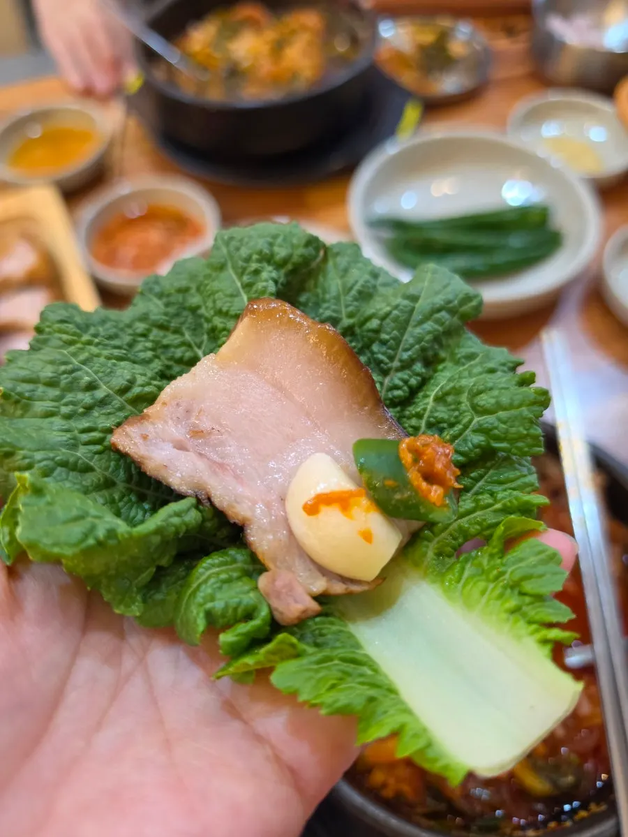 A wrap of dombe pork topped with garlic and chili