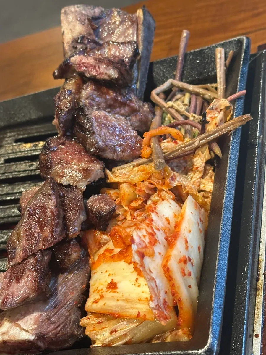 불판 위 우대갈비와 함께 구워지는 김치, 버섯
