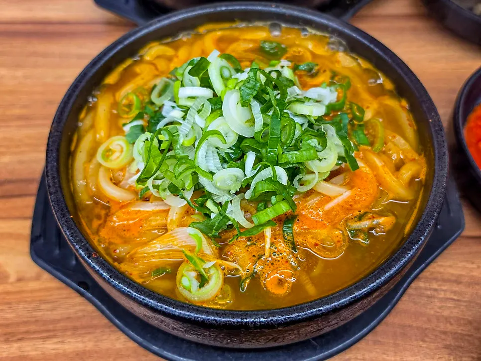 Stone pot of mild pork bone udon soup with savory broth