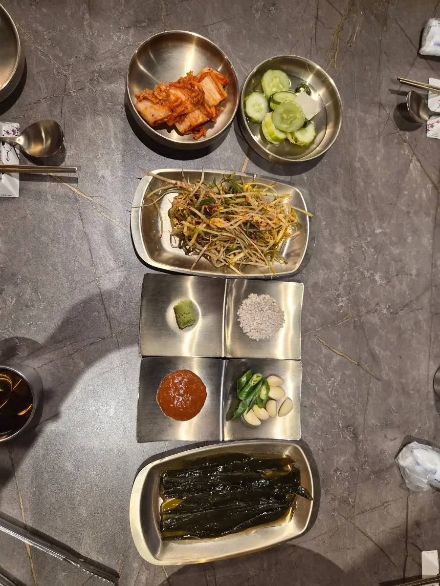 Basic side dish spread including kimchi and pickled cucumber