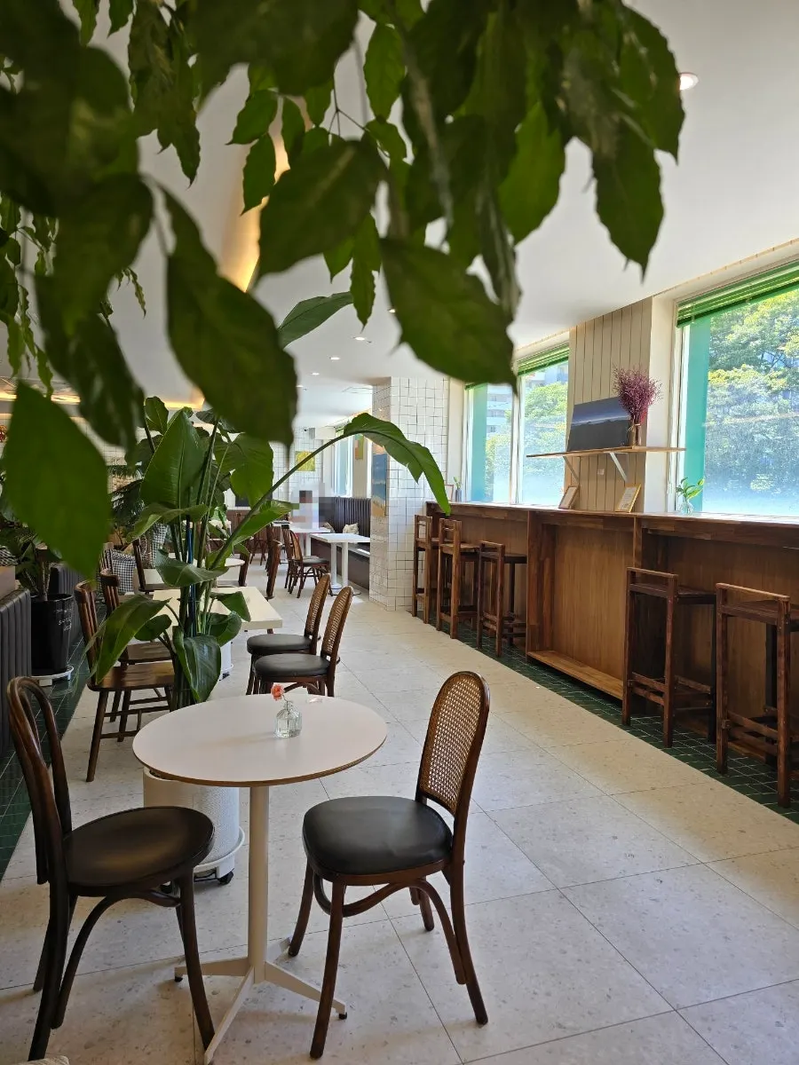 Café interior with large windows and potted plants