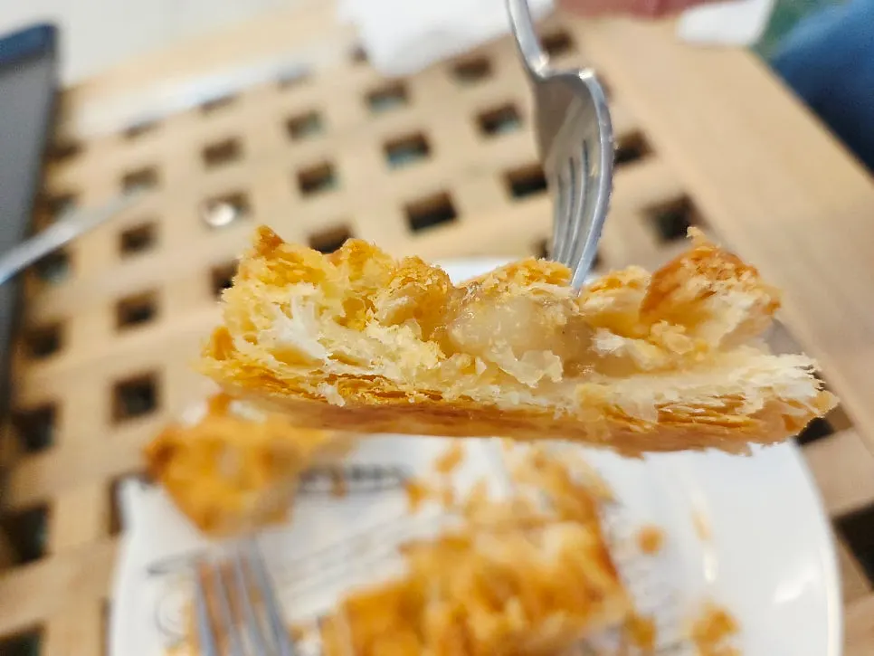 Apple pie cut open with a fork, showing the layered crust