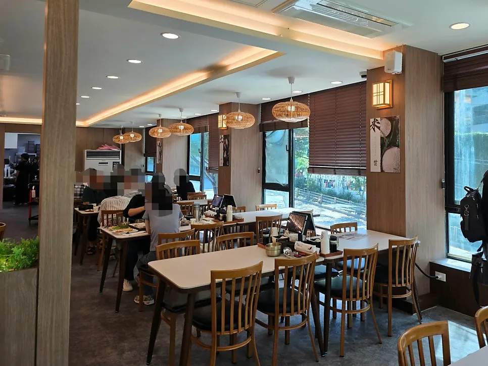 Bright dining hall lit by floor-to-ceiling windows