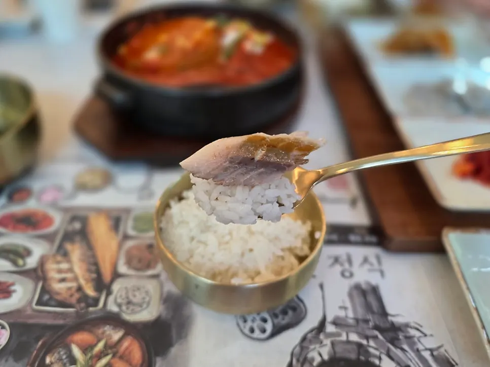 A piece of grilled mackerel on top of warm rice