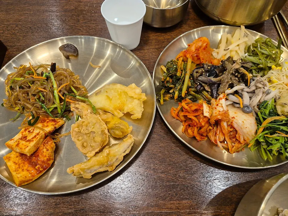 Plate of fried items, braised tofu, and japchae side dishes