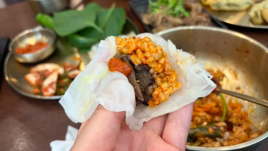 A spread of perilla leaf wraps, pork, and cheonggukjang