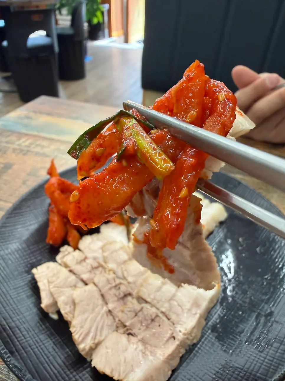 Sepotong daging bossam dengan bossam-kimchi