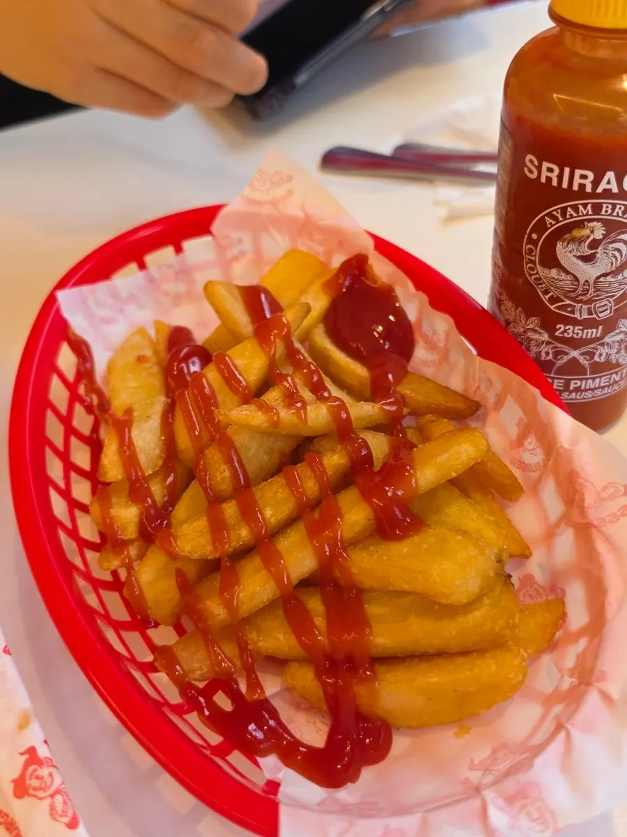 Fries topped with ketchup and sriracha sauce
