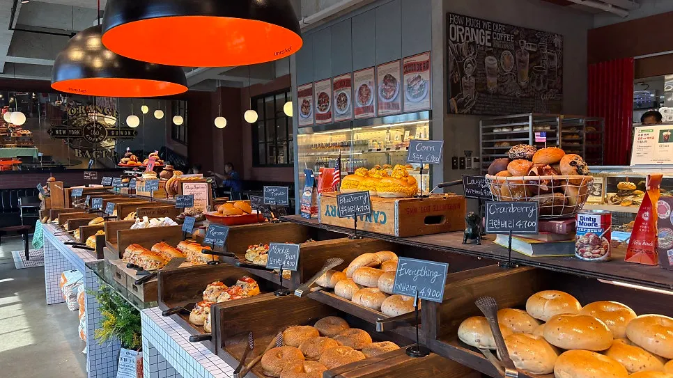 Menu board for bagels and cream cheese at Orange Bagel