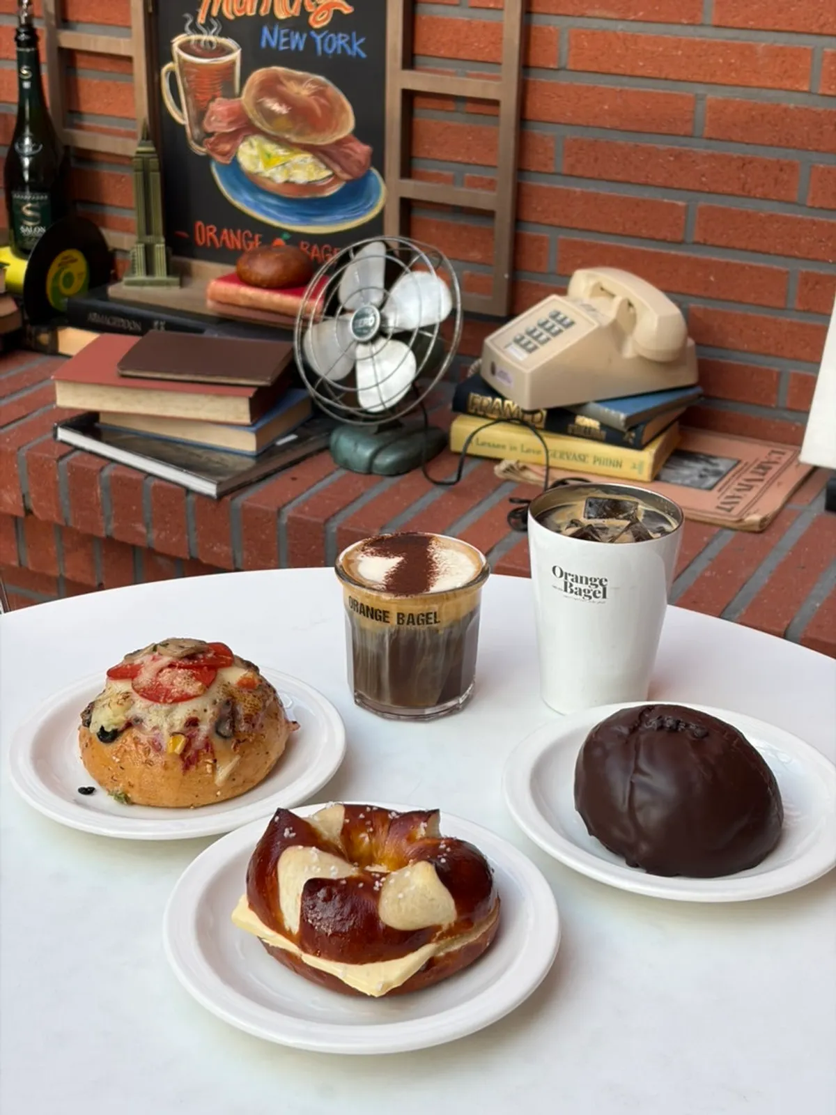 Table set with three bagel types and drinks at Orange Bagel