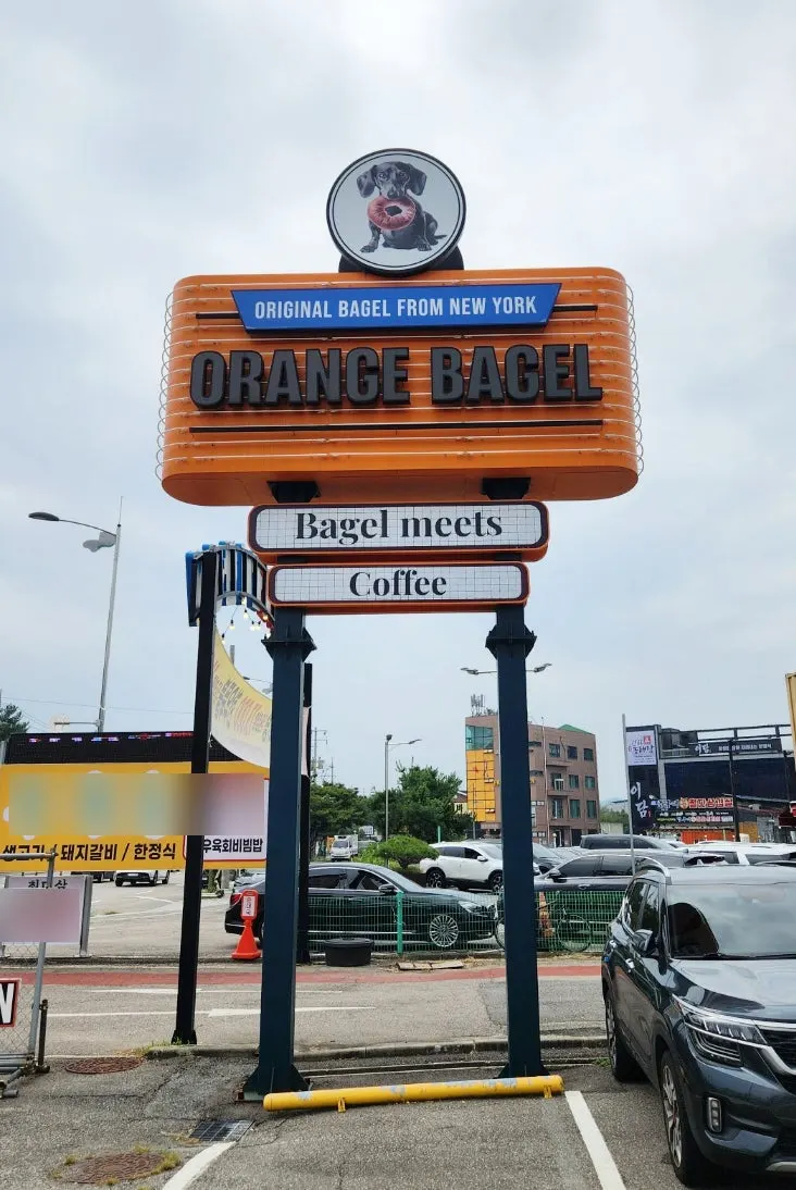 Vertical photo of the Orange Bagel entrance signboard