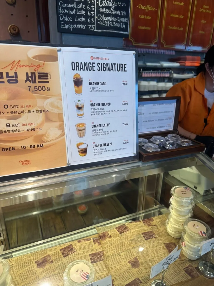 Ordering guide and partnership signage at Orange Bagel