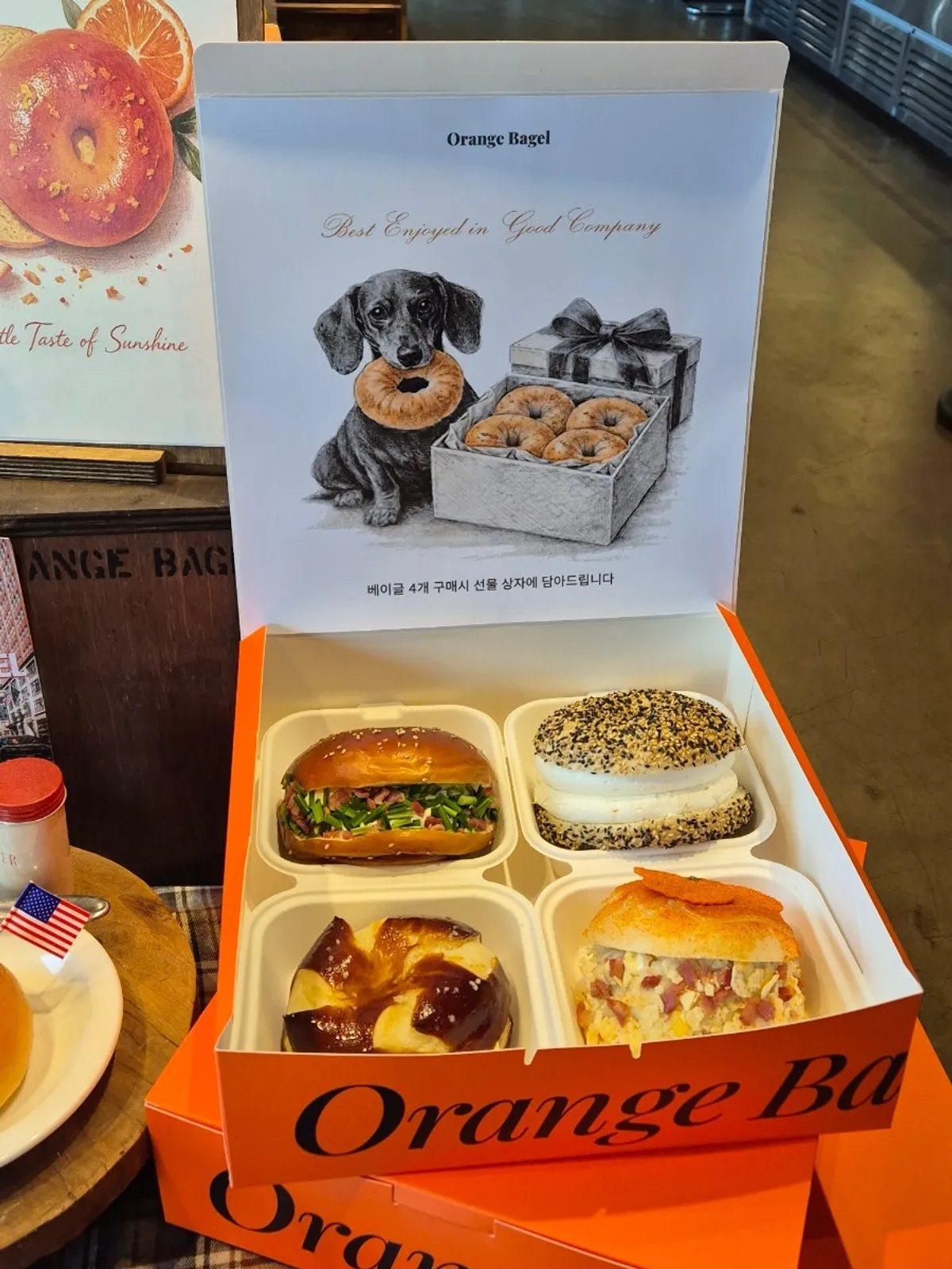 Orange Bagel takeout container with bagels