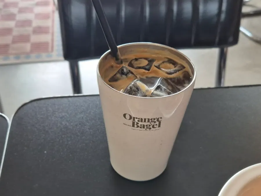 A cup of coffee enjoyed with a bagel