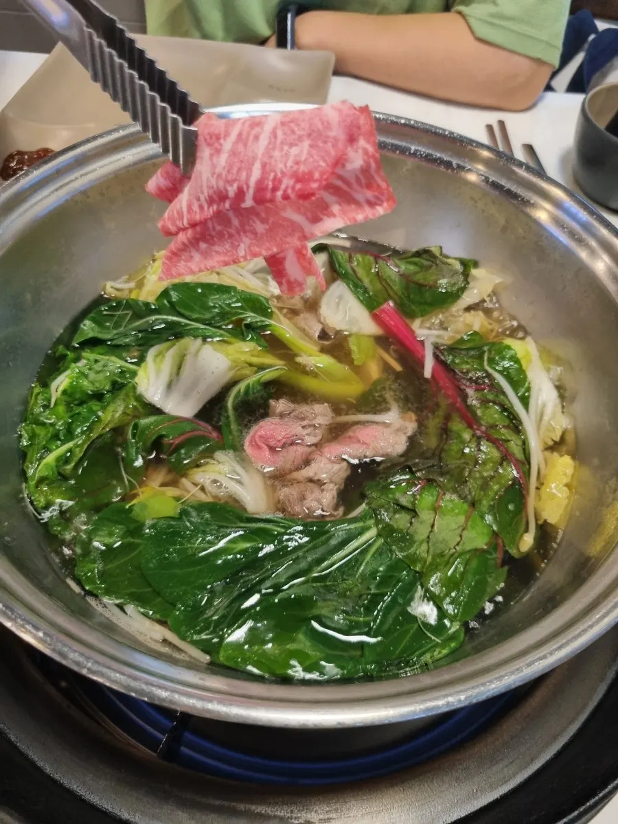 Shabu shabu broth simmering with added ingredients