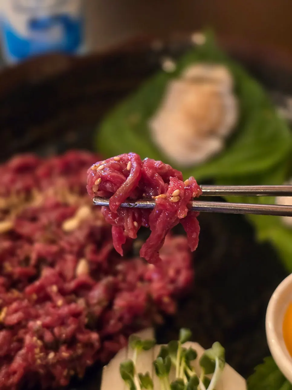 Yukhoe and abalone served on top of perilla leaves