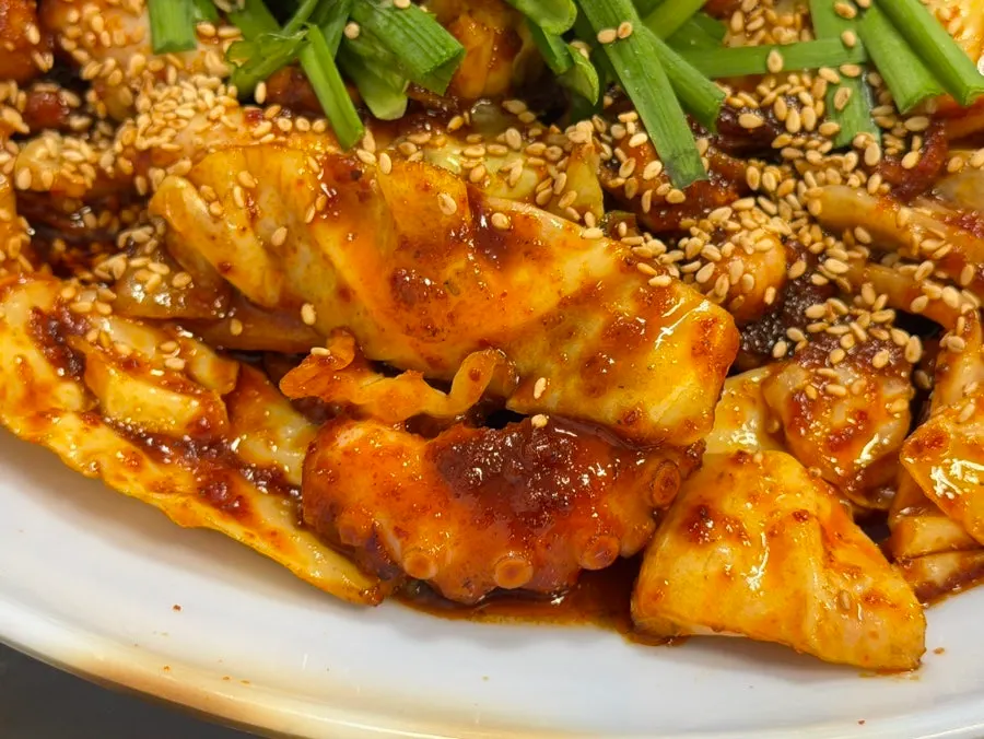 Close-up of glossy, chunky octopus stir-fry