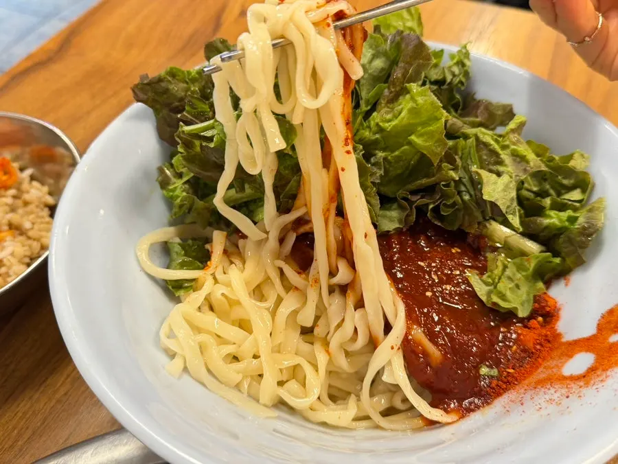 Kalguksu noodles evenly coated in seasoning sauce